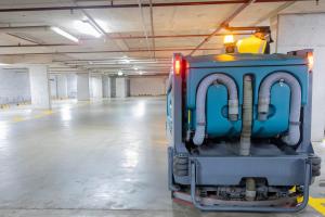 Industrial floor cleaning machine in operation within a spacious warehouse facility with polished concrete flooring