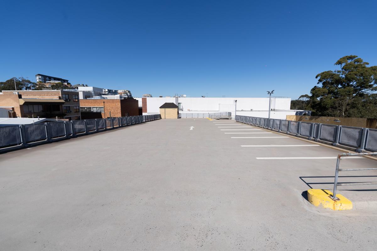 Large industrial warehouse car park with concrete flooring, storage containers, and clear markings