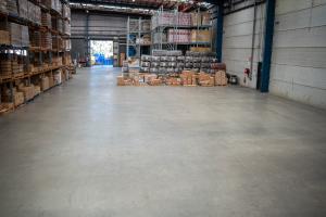 Large warehouse facility with organised pallet storage, racking systems, and clean concrete flooring