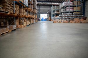 Large warehouse facility with organised pallet storage, metal racking systems, and clean concrete flooring