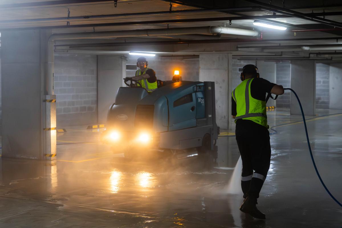 Industrial car park cleaning with high-pressure water jetting equipment and professional workers